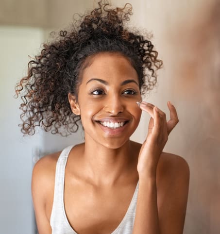 Young black woman applying skin cream RF MICRONEEDLING IN NEW YORK, NY
