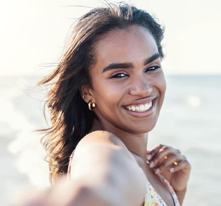 Close up of delightful afro woman taking selfie at the beach in summery day - Beautiful black girl smiling looking at camera outside - Fashion lifestyle and beauty concept Latisse® in New York, NY